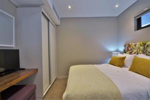 een slaapkamer met een bed en een televisie bij 418 Zimbali Suites in Ballito