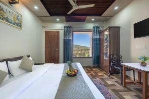 a bedroom with a large white bed and a table at Snowfall View Home Kasauli Operated by Splendid Hotels in Kasauli +16 photos