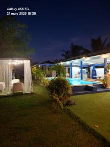 a backyard of a house with a pool at night at Fare Oasis in Temae