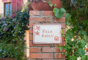 ポルトフェッラーイオにあるVilla Giolùの煉瓦壁のヴィラクラブの看板