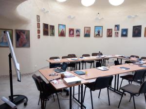 Ein Raum mit Reihen von Tischen und Stühlen, an dessen Wänden Bilder hingen. in der Unterkunft Meduza Hotel in Palanga + 50 Fotos