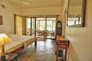 a bedroom with a bed and a table and a room at halo in Ahangama