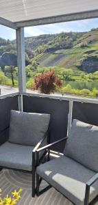 two chairs on a balcony with a view of a vineyard at Moselhof in Burg