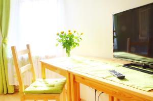 einen Tisch mit einem Fernseher und einer Vase Blumen drauf in der Unterkunft Kessenbrock Appartements in Witten