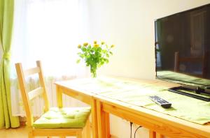 a table with a television and a vase of flowers on it at Kessenbrock Appartements in Witten