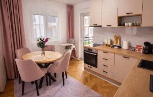 a kitchen with a table and chairs in a room at Alma Apartment - Family Stay Across Aqua Park Raj in Vrnjačka Banja