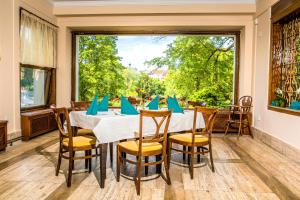 a dining room with a table and chairs and a large window at Manor House in Broumov