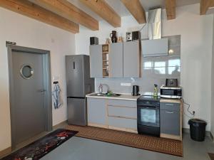 a kitchen with white cabinets and a refrigerator at Pension Garage in Kutná Hora