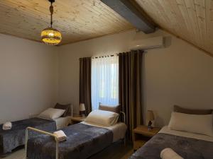 a bedroom with two beds and a window at Guesthouse 3 Diamonds in Omarë