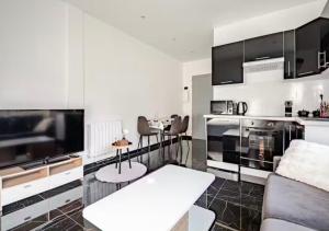 a living room with a couch and a kitchen at Loft design climatisé in Thiais