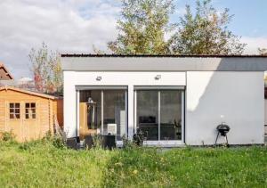 a white house with large glass doors in a yard at Loft design climatisé in Thiais