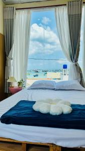 a bedroom with a bed with a view of the ocean at Home Sake Hòn Sơn in Lai Sơn