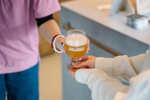 a person is holding a glass of beer at APARTMENTS by Bed and Craft in Inami