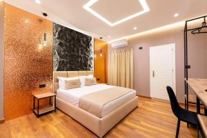 a bedroom with a large white bed and a table at Bliss Boutique Hotel in Durrës
