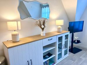 a room with a desk with two lamps and a tv at Cap des pins in Quend