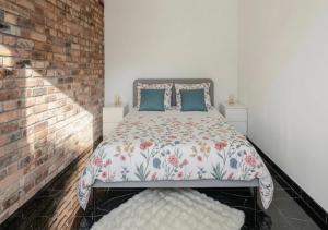 a bedroom with a bed and a brick wall at Loft design climatisé in Thiais