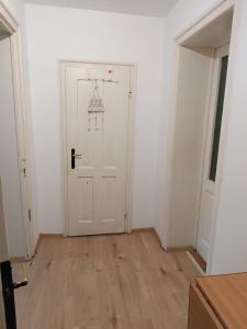 an empty room with a white door and wooden floors at Casa ANDA in Braşov