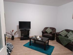 a living room with two couches and a tv at Casa ANDA in Braşov