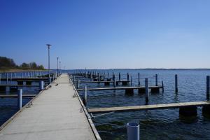 a dock in the water with a pier at Blockhaus Fleesensee in Silz +9 photos