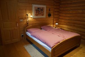 a bedroom with a bed in a wooden room at Blockhaus Fleesensee in Silz