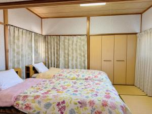 a bedroom with two beds and cabinets and a bed at 別府ホーム in Beppu