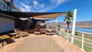 a patio with chairs and a large umbrella on a house at Clanwilliam Waterside Villa in Clanwilliam