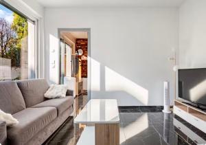 a living room with a couch and a tv at Loft design climatisé in Thiais
