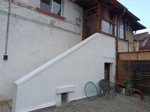 a white building with a balcony with a table and chairs at Casa ANDA in Braşov