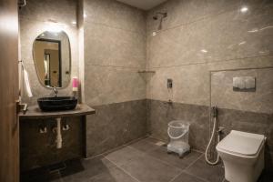a bathroom with a toilet and a sink and a mirror at OPO Horizon Aerocity ,Delhi Airport in Jāmb