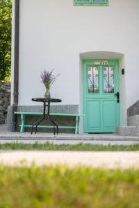 a green door and a table in front of a building at Pri Dopivcu in Log pod Mangartom