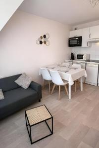 a living room with a couch and a table with chairs at Cap des pins in Quend +22 photos