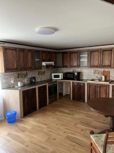 an empty kitchen with wooden cabinets and a table at У Блищака in Pilipets