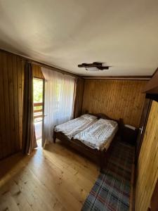 a bedroom with a bed in a room with a window at У Блищака in Pilipets
