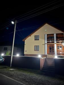 a house with a staircase in front of it at night at У Блищака in Pilipets