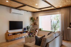 a living room with a couch and a flat screen tv at Kodok House in Melbourne