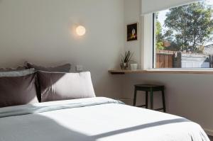 a bedroom with a white bed and a window at Kodok House in Melbourne