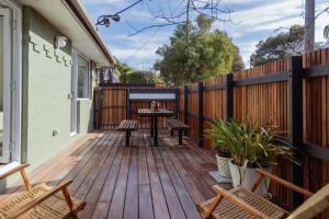 a wooden deck with a table and chairs on a house at Kodok House in Melbourne