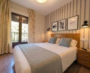 a bedroom with a large bed and a window at Hospedería Puerta de la Catedral in Ciudad-Rodrigo