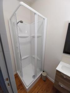 a glass shower in a bathroom with a white wall at Gîte La Caillère in Moncoutant +19 photos
