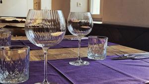 a table with four wine glasses on a purple table cloth at Endorfer Stubn in Bad Endorf +13 photos
