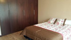 - une chambre avec un lit et des placards en bois dans l'établissement Casa Vacacional, à Cuenca