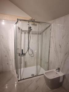 a shower with a glass door next to a sink at Hotel HDomus in Nogarole Rocca