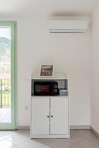 a white cabinet with a microwave on top of it at Sunset Apartment 2Bedr Sunset View Parking in Bosa