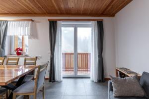 a dining room with a table and chairs and a window at Apartmaji Peternelj in Železniki