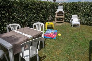 a group of chairs and a table in the grass at Villetta Tina in Vada