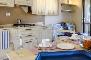 a kitchen with a table and chairs and a kitchen with a tableablish at Villetta Tina in Vada