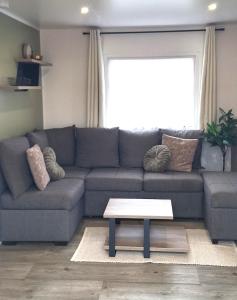 a living room with a couch and a coffee table at Chalet Lauwersoog mét airco! in Lauwersoog