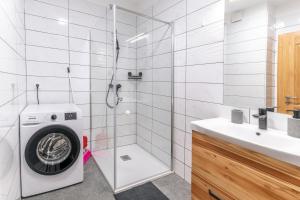 a bathroom with a washing machine and a shower at Apartmaji Peternelj in Železniki +18 photos