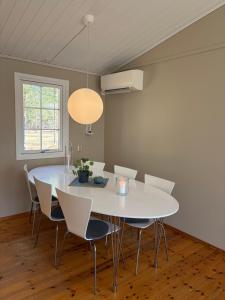 a dining room with a white table and chairs at Semesterhus nära Köpingsvik in Köpingsvik