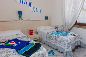 two beds in a room with towels on the floor at Villetta Tina in Vada